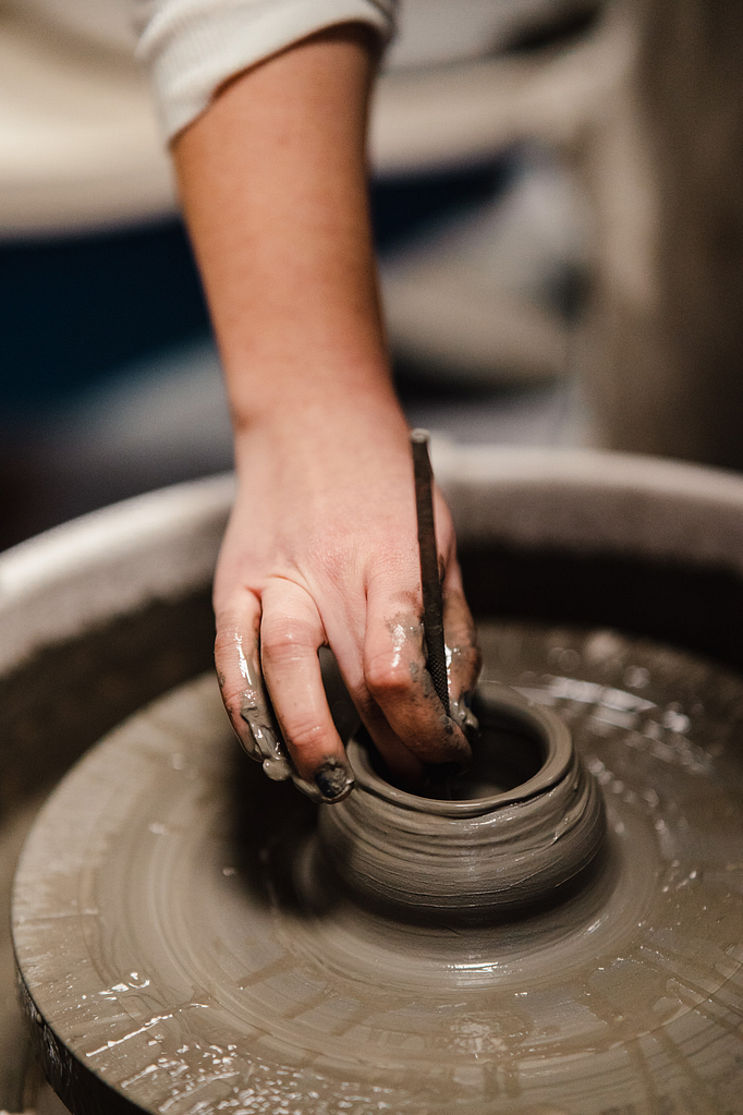 Reportage photo dans un atelier de céramiques et zoom sur la main de l'artisan