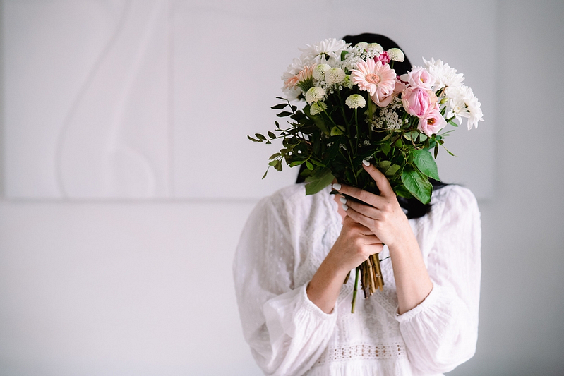 Photo de branding mettant en scène une femme cachée derrière un bouquet de fleurs
